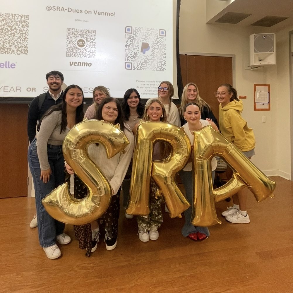 Students from the Student Retail Association holding SRA balloons and smiling