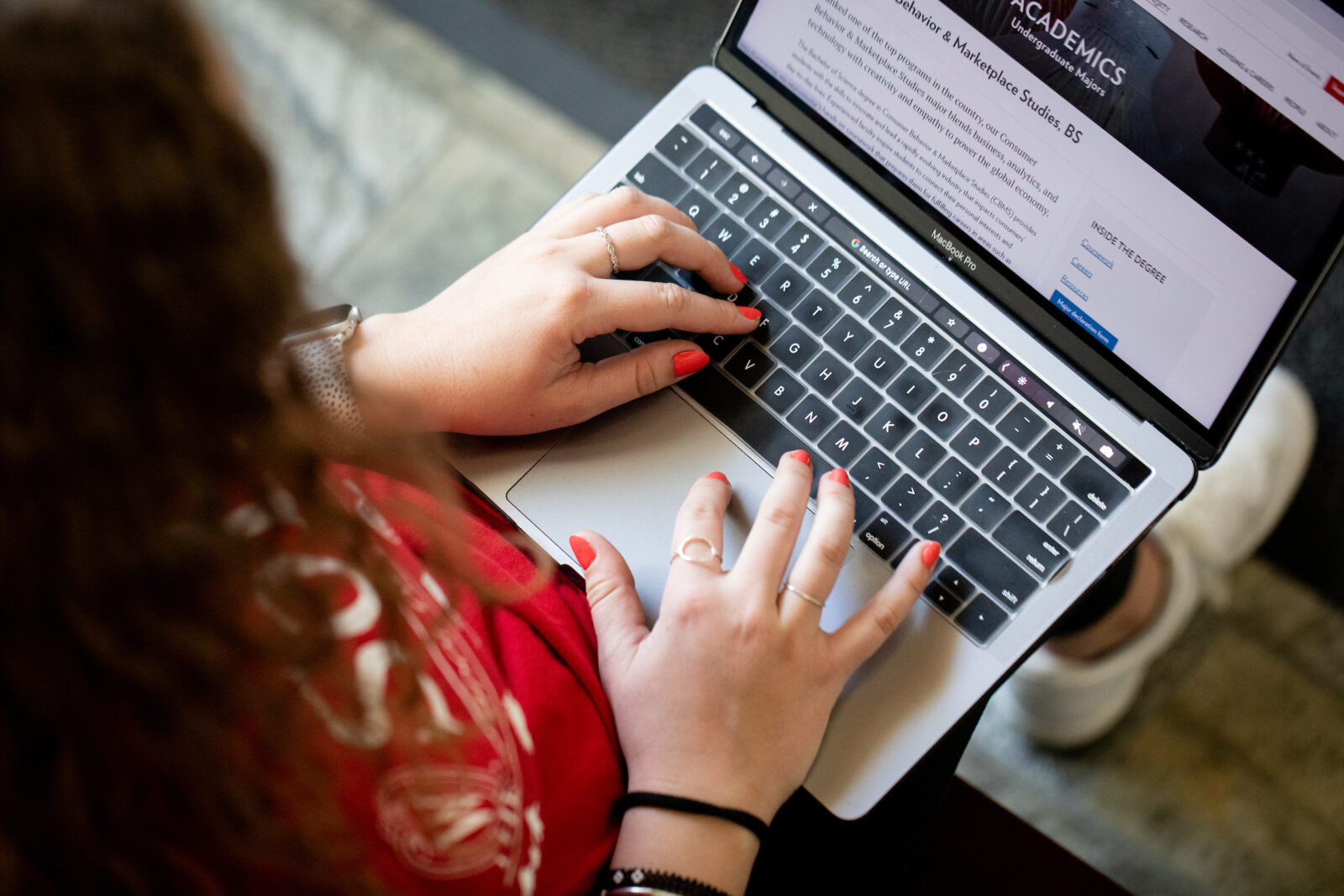 Student sitting at a computer reviewing degree program.